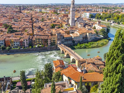 View of the historic center of the city of Verona, Italy and the Ponte Pietra bridge and river Adige from the hillside fortress of Castel San Pietro, with groups of rafters enjoying a ride on the river. View of the historic center of the city of Verona, Italy and the Ponte Pietra bridge and river Adige from the hillside fortress of Castel San Pietro, with groups of rafters enjoying a ride on the river.