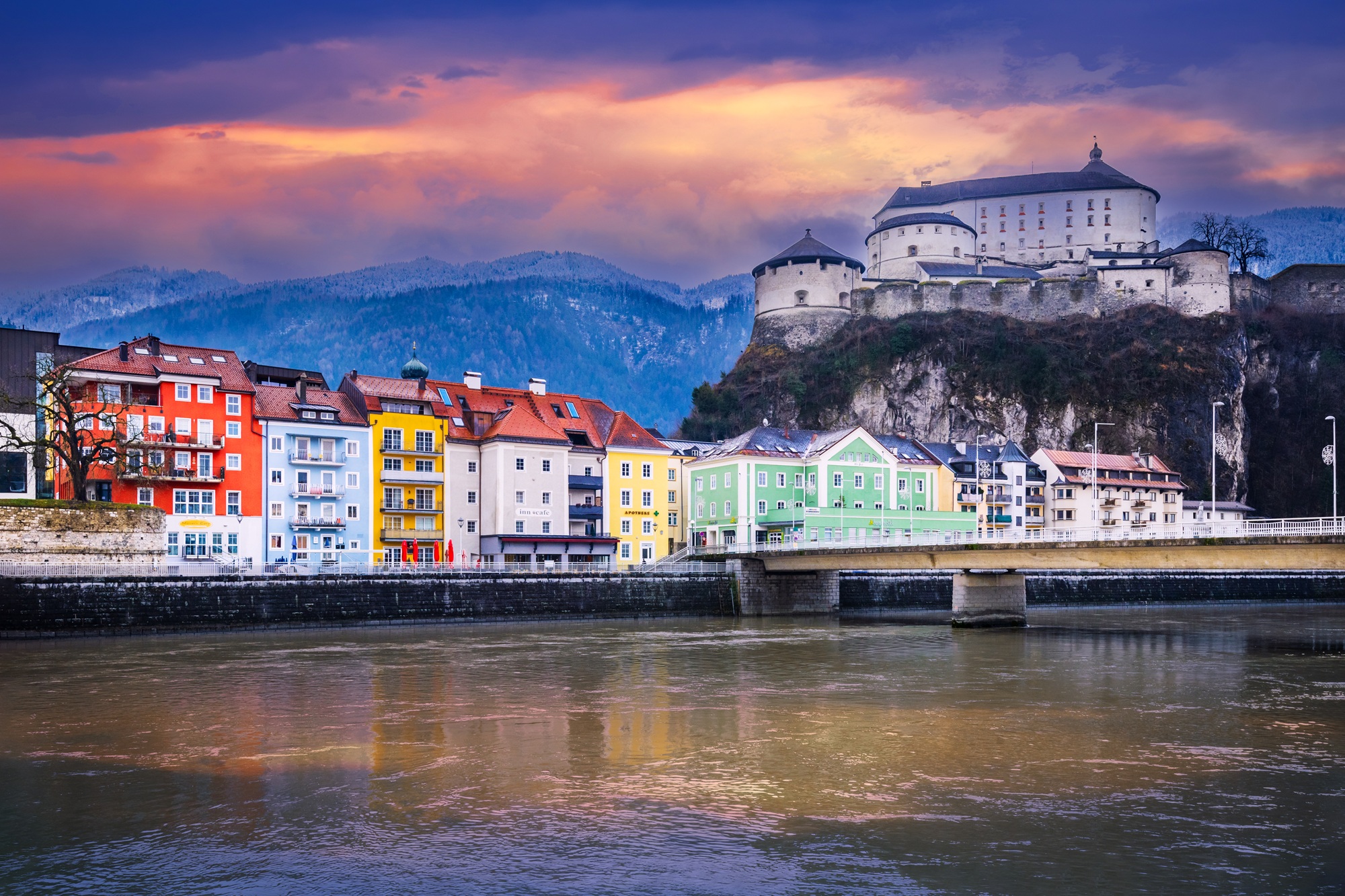 Kufstein, Österreich Morgennebel über Kufstein in Österreich im Dezember: Blick auf den Stadtplatz mit bunten, traditionellen Häusern vor winterlicher Kulisse im Tiroler Unterland.